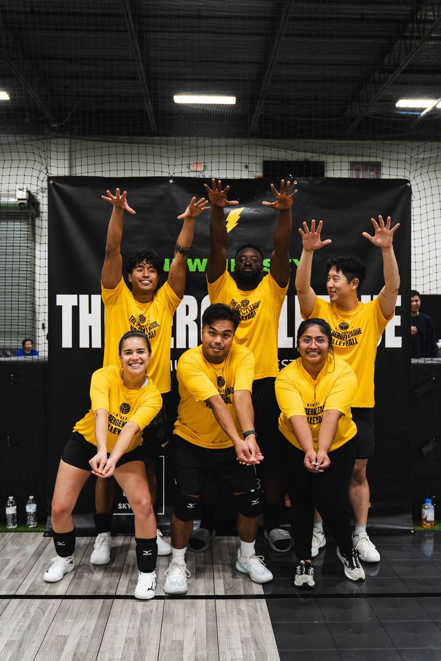 Volleyball team in yellow, bumping pose